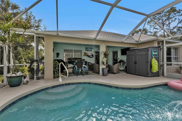 rear view of property featuring glass enclosure and a patio area