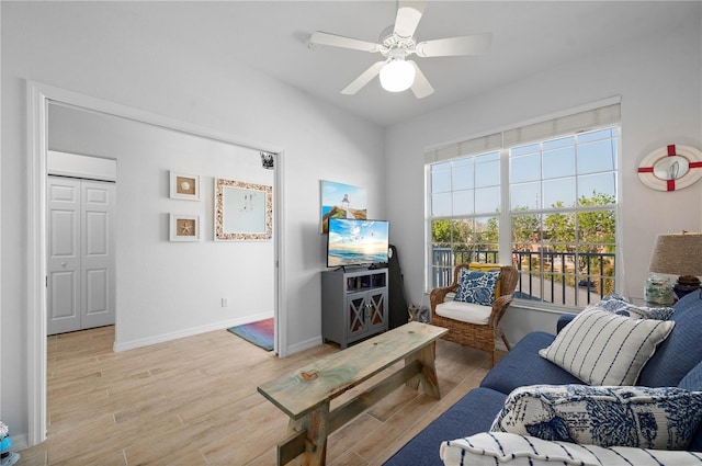 living room featuring ceiling fan and light hardwood / wood-style floors