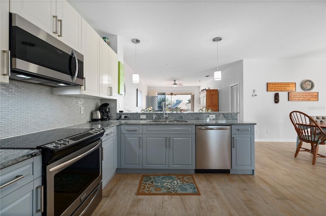 kitchen with gray cabinetry, pendant lighting, sink, appliances with stainless steel finishes, and white cabinetry