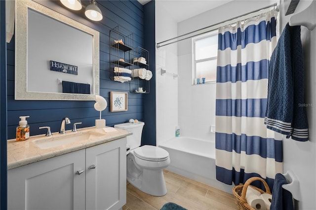 full bathroom featuring shower / tub combo, vanity, toilet, and wooden walls