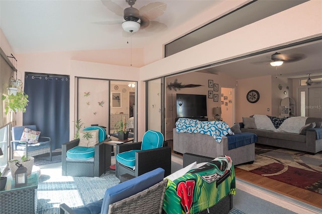 living room with lofted ceiling, ceiling fan, and wood-type flooring