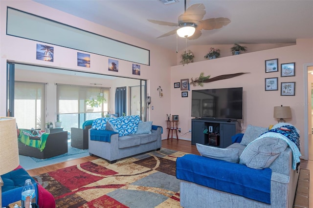 living room with lofted ceiling, ceiling fan, and wood-type flooring