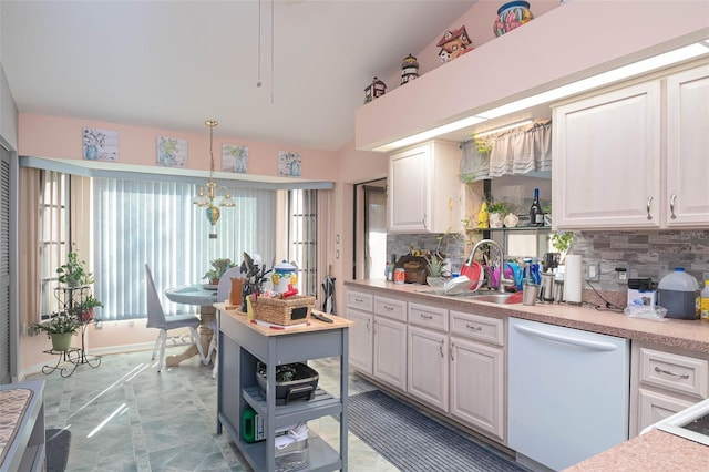 kitchen featuring tasteful backsplash, white dishwasher, decorative light fixtures, a notable chandelier, and plenty of natural light