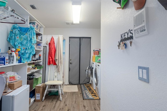 laundry room with light wood-type flooring and independent washer and dryer