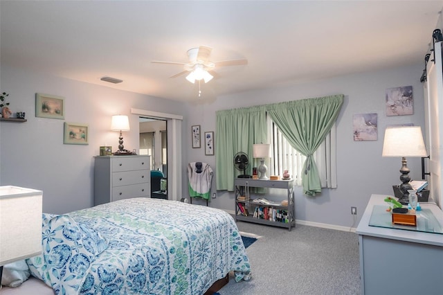 carpeted bedroom with ceiling fan and a closet