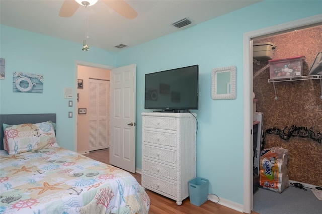 bedroom with wood-type flooring, a closet, and ceiling fan