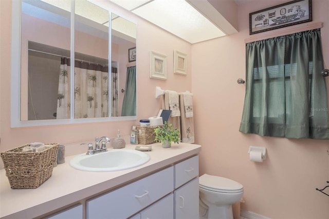 bathroom with vanity, curtained shower, and toilet