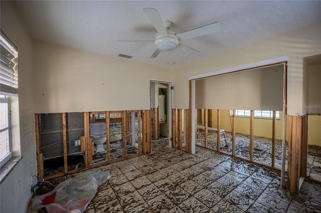 unfurnished bedroom featuring ceiling fan and a textured ceiling