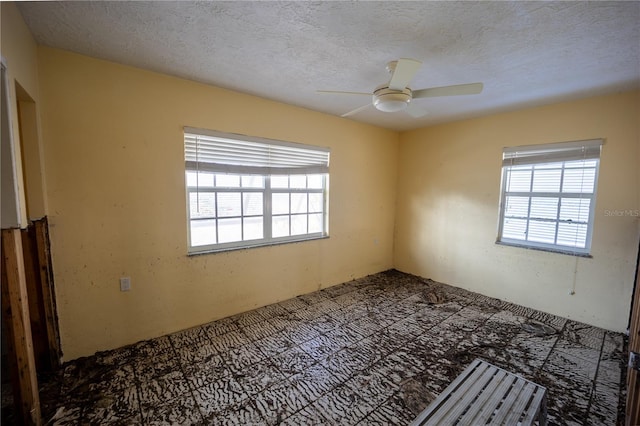 empty room featuring ceiling fan and a textured ceiling