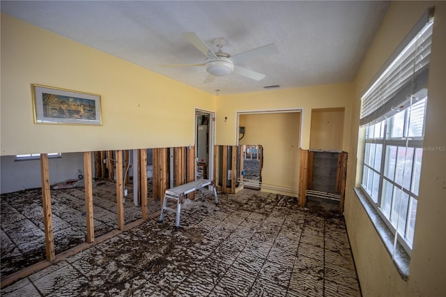 interior space with ceiling fan and a textured ceiling