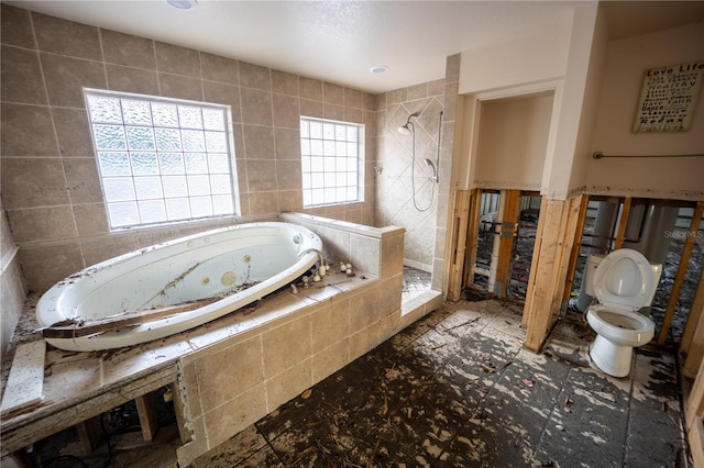 bathroom featuring tile walls, toilet, and separate shower and tub