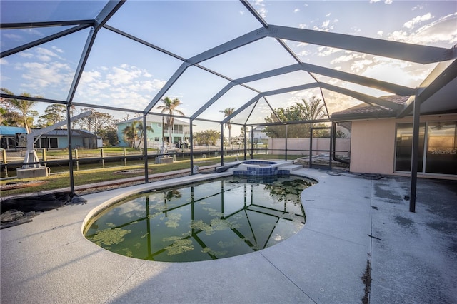 view of pool with a patio area, an in ground hot tub, and glass enclosure