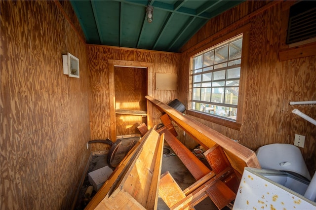 staircase featuring vaulted ceiling and wood walls