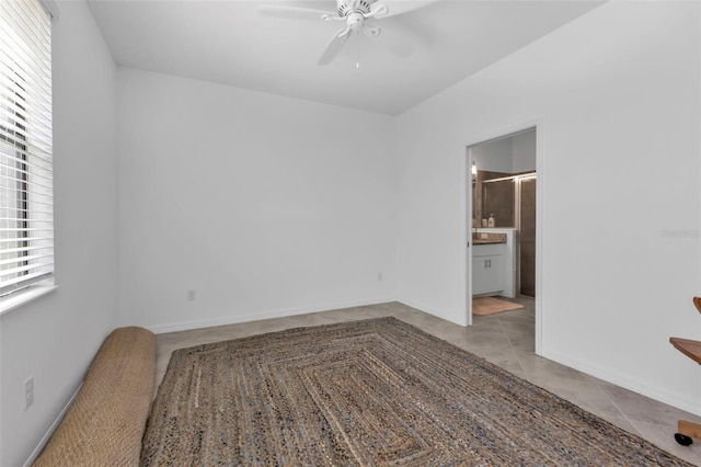 tiled empty room featuring ceiling fan