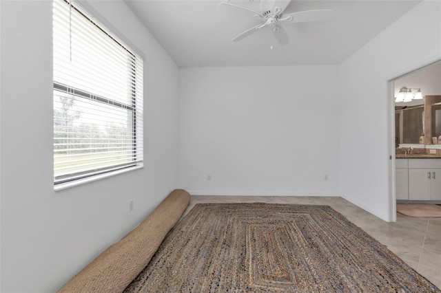 tiled empty room featuring ceiling fan and sink