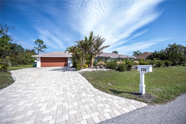 view of front of property with a garage and a front lawn