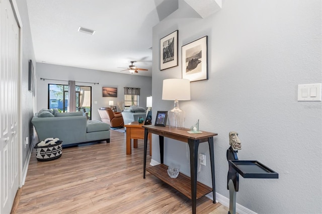 living room featuring ceiling fan and light hardwood / wood-style floors