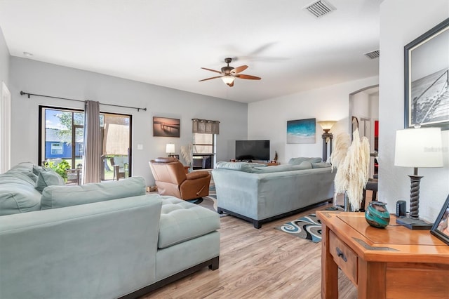 living room featuring light wood-type flooring and ceiling fan