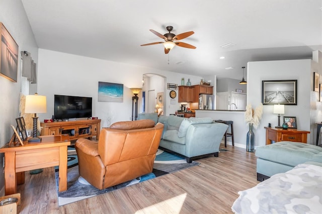 living room featuring ceiling fan and light wood-type flooring