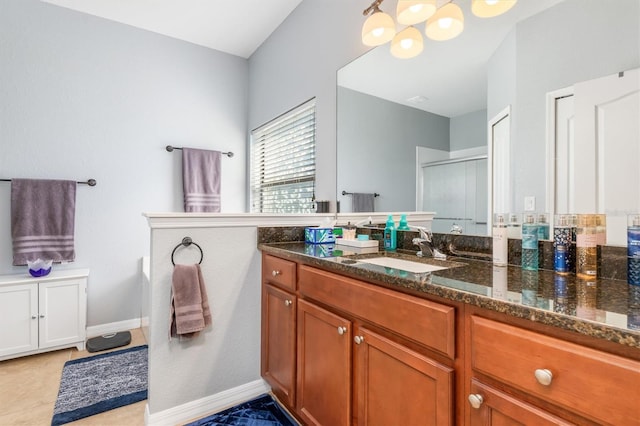 bathroom featuring tile patterned floors, a shower with door, and vanity