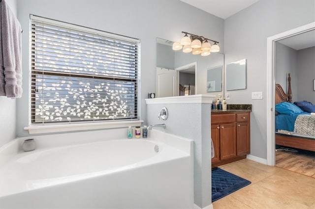 bathroom with a bathing tub, tile patterned flooring, and vanity