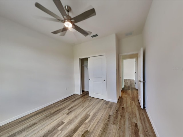 unfurnished bedroom featuring a closet, light hardwood / wood-style flooring, and ceiling fan