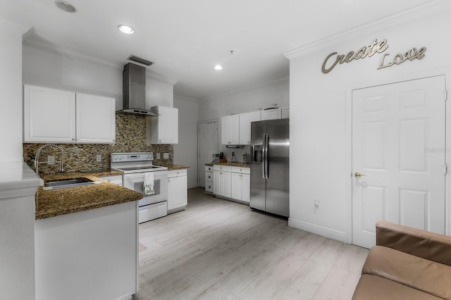 kitchen featuring white cabinetry, sink, wall chimney exhaust hood, white range with electric cooktop, and stainless steel fridge