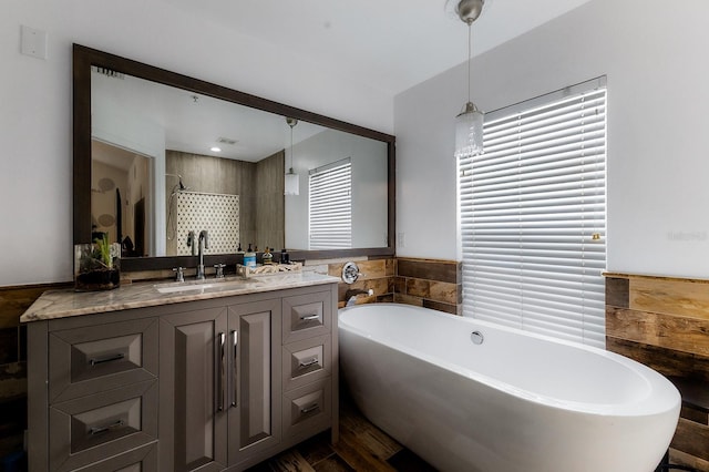 bathroom featuring hardwood / wood-style flooring, vanity, and plus walk in shower