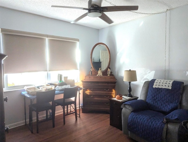 sitting room with ceiling fan, dark hardwood / wood-style flooring, and a textured ceiling