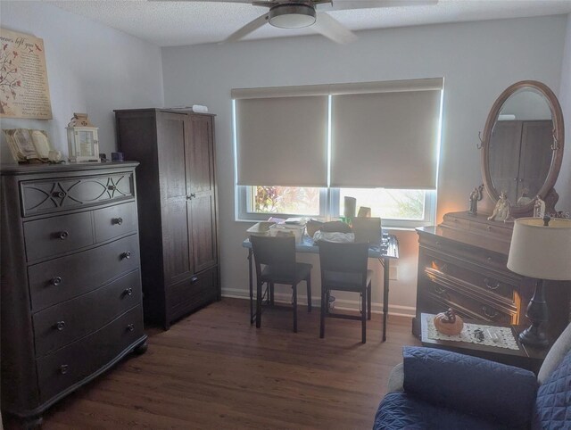 home office with a textured ceiling, dark hardwood / wood-style floors, and ceiling fan