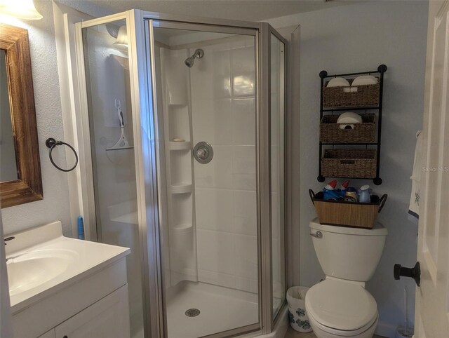 bathroom featuring vanity, toilet, and walk in shower