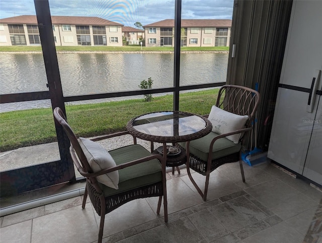 sunroom / solarium featuring a water view and a healthy amount of sunlight