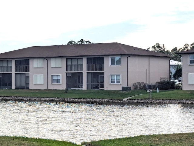 back of property with a yard and central AC