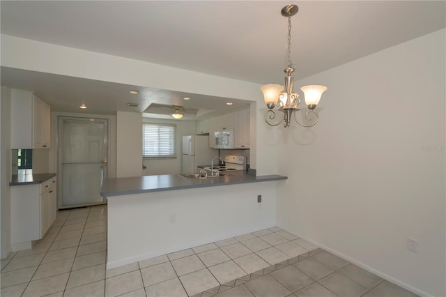 kitchen with white appliances, white cabinets, light tile patterned floors, kitchen peninsula, and a chandelier