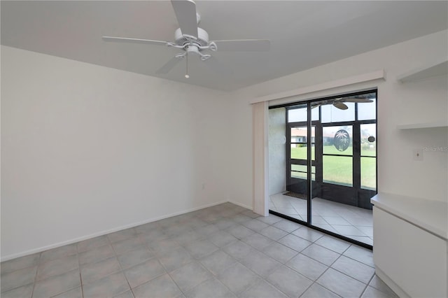 spare room with ceiling fan and light tile patterned flooring