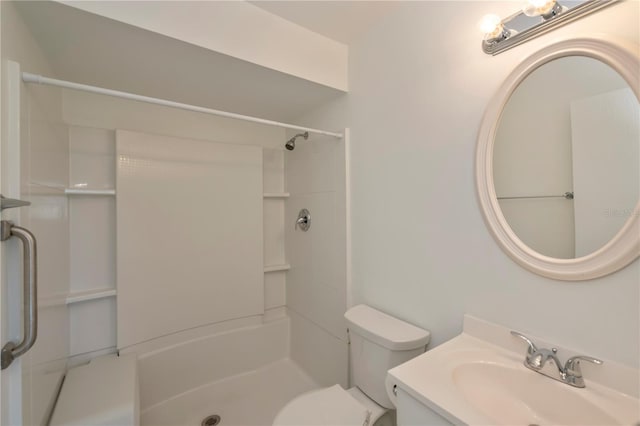 bathroom with toilet, a shower, and vanity