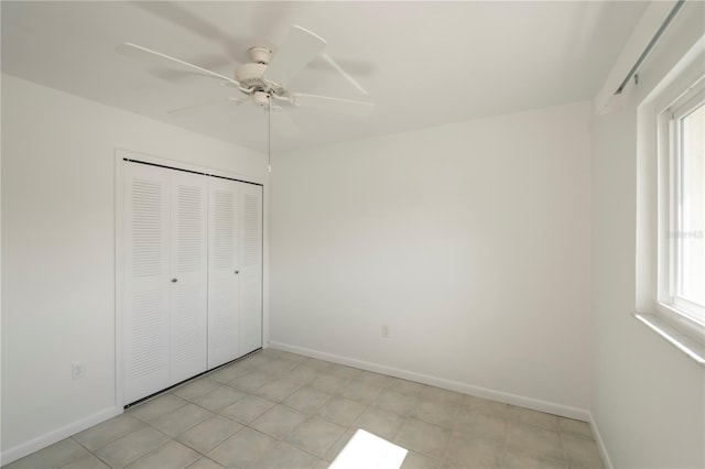 unfurnished bedroom featuring light tile patterned floors, a closet, multiple windows, and ceiling fan