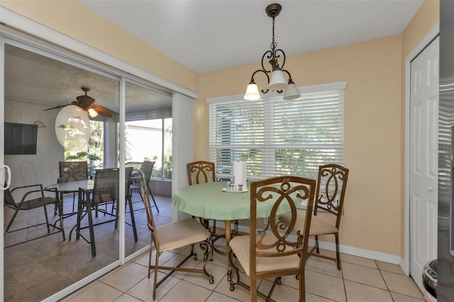 tiled dining area with ceiling fan with notable chandelier