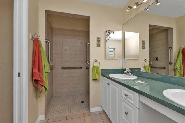 bathroom with tile patterned flooring, vanity, and tiled shower