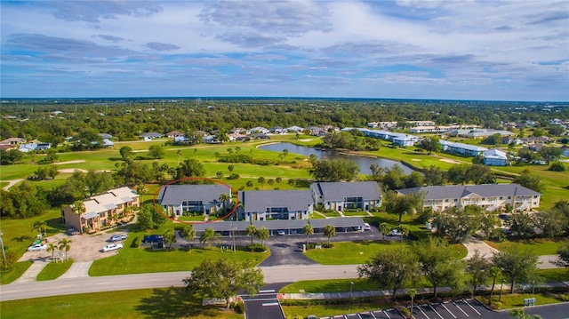 drone / aerial view featuring a water view, view of golf course, and a residential view