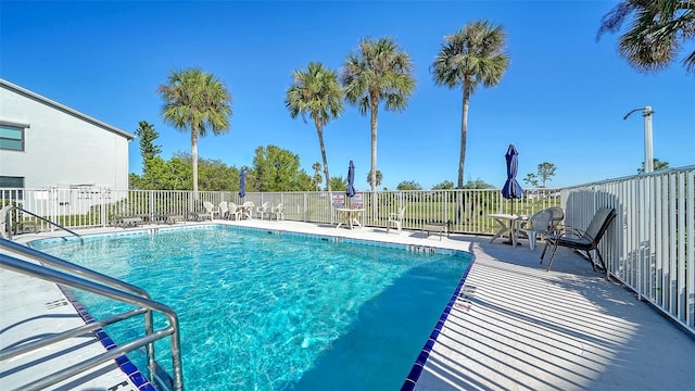 community pool featuring fence and a patio