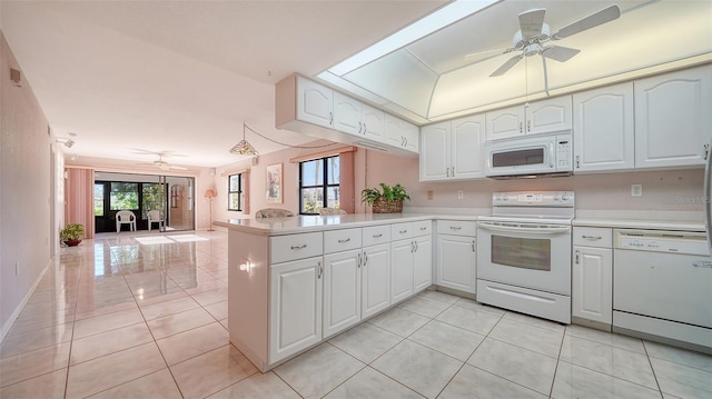 kitchen with white cabinetry, white appliances, kitchen peninsula, and a wealth of natural light