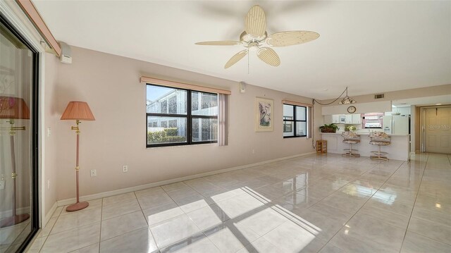 interior space with light tile patterned floors and ceiling fan