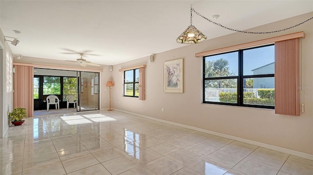 unfurnished room with ceiling fan, baseboards, and light tile patterned flooring