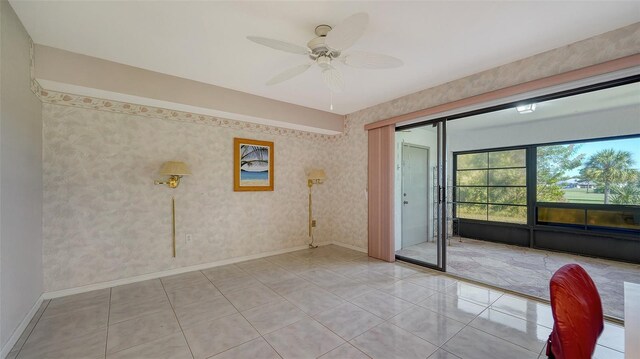 spare room featuring baseboards, light tile patterned floors, and wallpapered walls