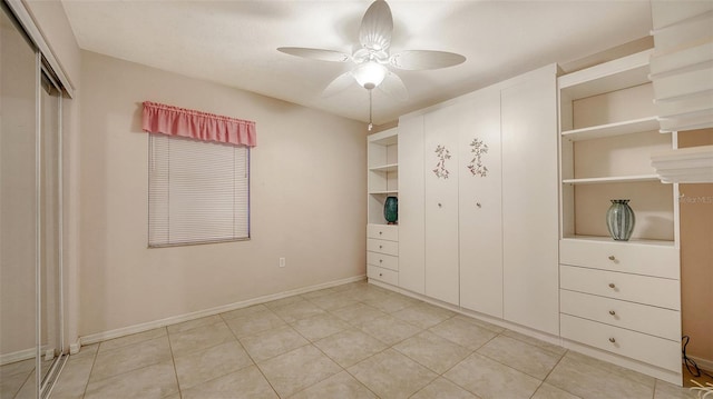 unfurnished bedroom with a ceiling fan, a closet, light tile patterned flooring, and baseboards