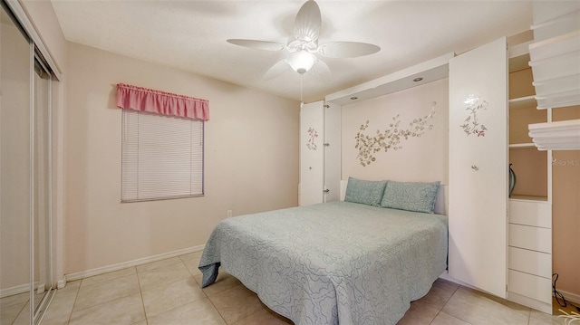 bedroom with a closet, ceiling fan, baseboards, and light tile patterned floors