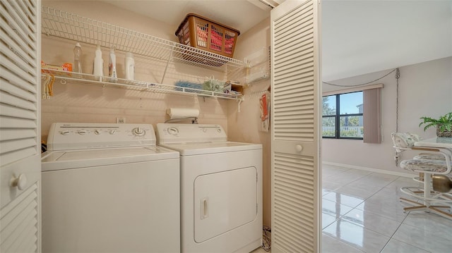 laundry room featuring washing machine and dryer and light tile patterned floors