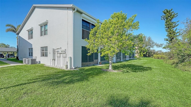 view of property exterior with central AC, a yard, and stucco siding