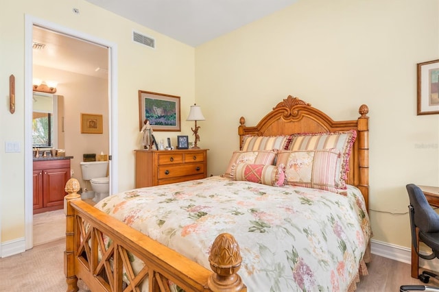 bedroom with ensuite bathroom and light hardwood / wood-style flooring